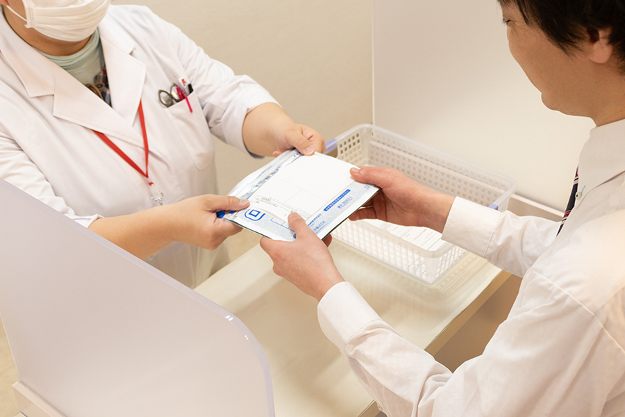 東花園駅北側にあるリリー薬局本店で薬の受け渡しをしている写真